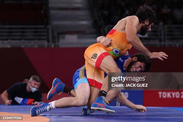 Russia's Zavur Uguev wrestles India's Kumar Ravi in their men's freestyle 57kg wrestling final match during the Tokyo 2020 Olympic Games at the...
