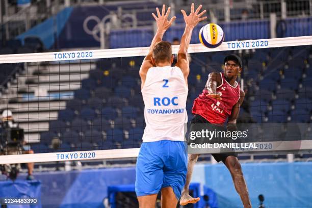 Qatar's Ahmed Tijan attempts a shot past Russia's Oleg Stoyanovskiy in their men's beach volleyball semi-final match between Qatar and Russia during...