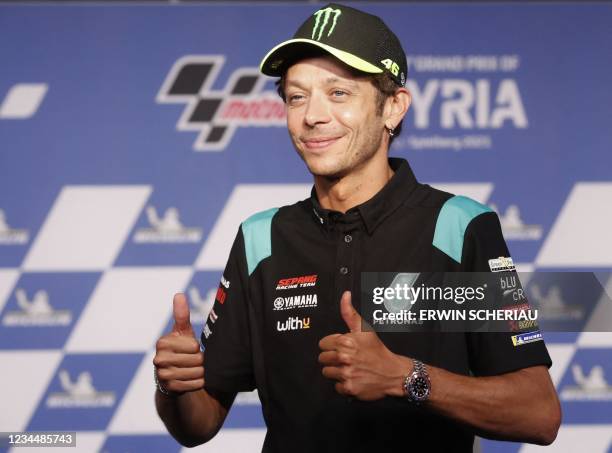 Yamaha-SRT Italian rider Valentino Rossi gives a thumbs up as he arrives to address a press conference to announce that he will retire at the end of...