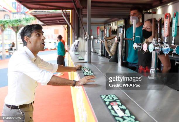 Britain's Chancellor Rishi Sunak speaks with previously furloughed staff at the London Wonderground comedy and music festival venue on August 5, 2021...