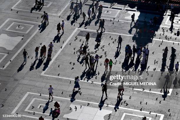 This picture taken from the roof of the Milan's Duomo Cathedral on August 5 shows tourists strolling in Duomo square in central Milan.