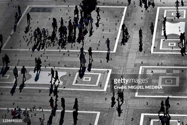 This picture taken from the roof of the Milan's Duomo Cathedral on August 5 shows tourists strolling in Duomo square in central Milan.