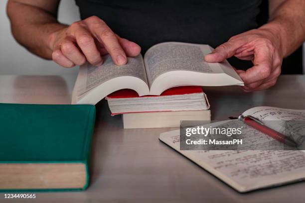 man reading a book - ortografía fotografías e imágenes de stock