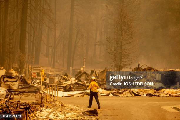 Firefighter surveys a destroyed downtown during the Dixie fire in Greenville, California on August 5, 2021. - The largest wildfire in California has...