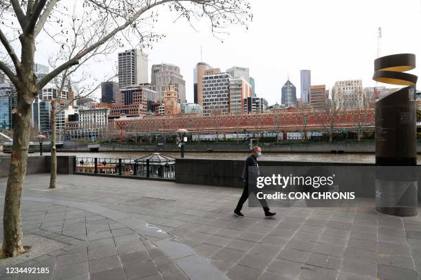 Man walks along Southbank in downtown Melbourne on August 6 amid a sixth lockdown for the city in efforts to bring the Delta outbreak to heel.