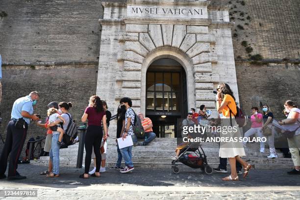 Visitors queue to show their Covid-19 certificates for scanning before entering the Vatican Museums in the Vatican on August 6 as Italy made the...