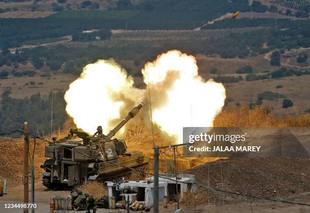 Israeli self-propelled howitzers fire towards Lebanon from a position near the northern Israeli town of Kiryat Shmona following rocket fire from the...