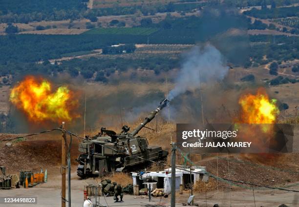 Israeli self-propelled howitzers fire towards Lebanon from a position near the northern Israeli town of Kiryat Shmona following rocket fire from the...