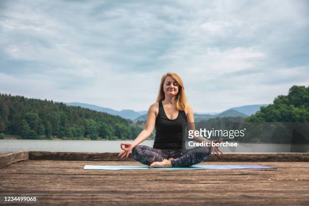 woman doing yoga in nature - lotus position imagens e fotografias de stock