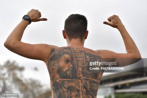 Fan shows his tatoos depicting Barcelona's Argentinian forward Lionel Messi in front of the Camp Nou stadium in Barcelona on August 6, 2021.