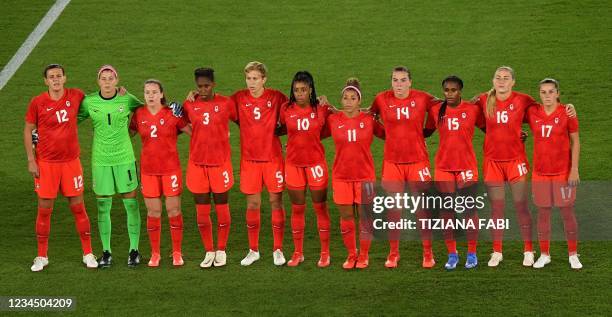 Canada's team players line up during national anthems prior the Tokyo 2020 Olympic Games women's final football match between Sweden and Canada at...