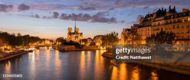 panoramic view of notre-dame de paris cathedral at sunset over seine river, paris, france - church color light paris stockfoto's en -beelden