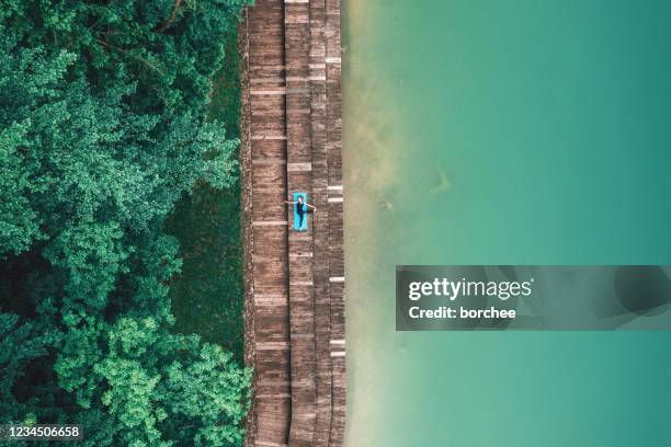 aerial view on woman doing yoga - slovenia beach stock pictures, royalty-free photos & images