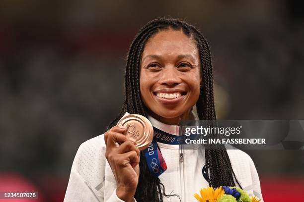 Bronze medallist USA's Allyson Felix celebrates on the podium during the medal ceremony for the women's 400m event during the Tokyo 2020 Olympic...