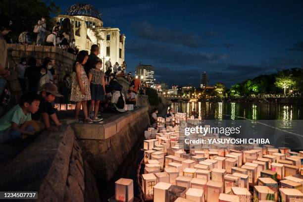 Members of local NPO release paper lanterns on Motoyasu River in front of beside the Hiroshima Prefectural Industrial Promotion Hall, as it was known...