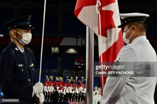 The Canada national flag is raised as gold medallists Canada's team stand on the podium for the victory ceremony after the Tokyo 2020 Olympic Games...