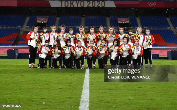 Gold medallists Canada's team pose with the medals during the victory ceremony after the Tokyo 2020 Olympic Games women's final football match at the...