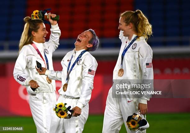 Bronze medallist USA's forward Megan Rapinoe smiles during the victory ceremony after the Tokyo 2020 Olympic Games women's final football match at...