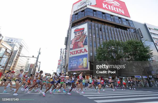 Runners move through the Susukino district during the women's marathon final during the Tokyo 2020 Olympic Games on August 7, 2021 in Sapporo, Japan.