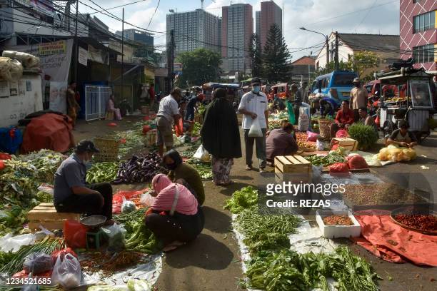 People shop for groceries at a traditional market in Bekasi, West Java, on August 7, 2021.