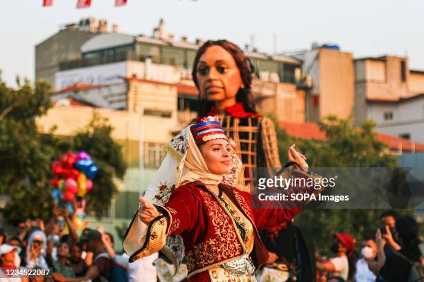 People wearing traditional outfits perform for the giant puppet "Amal" in Konak Square. Designed to bring the challenges faced by Syrian refugee...