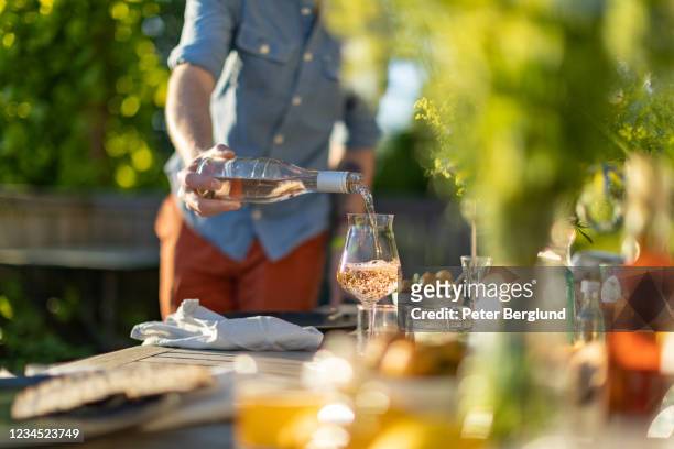 a man pours a glass of rosé wine - rose wine stock pictures, royalty-free photos & images