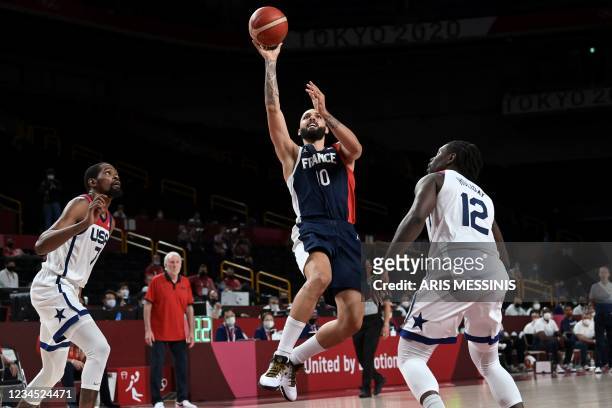 France's Evan Fournier goes to the basket past USA's Jrue Holiday in the men's final basketball match between France and USA during the Tokyo 2020...