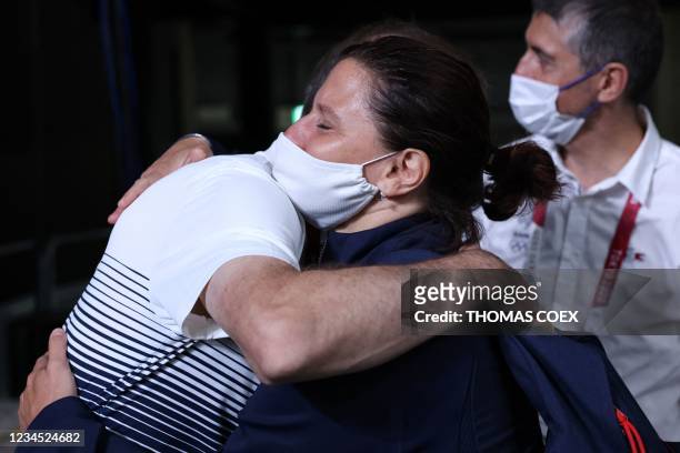 France's men's basketball team coach Vincent Collet embraces French Junior Sports Minister Roxana Maracineanu after the men's final match between...