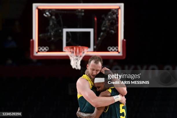 Australia's Joe Ingles and Patty Mills embrace as they celebrate their victory at the end of the men's bronze medal basketball match between Slovenia...