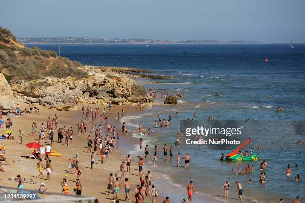 Beachgoers sunbathe and swim at Oura beach amid COVI-19 pandemic in Albufeira, Algarve region, Portugal on August 6, 2021.