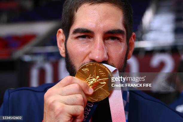 France's centre back Nikola Karabatic poses with gold medal after the medals ceremony for the men's final handball at the Tokyo 2020 Olympic Games at...