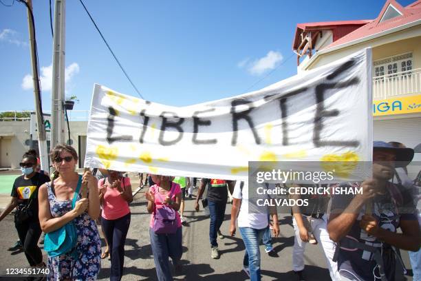 Demonstrators hold up banners and placards, one of which reads as "freedom", during a national day of protest against the compulsory Covid-19...