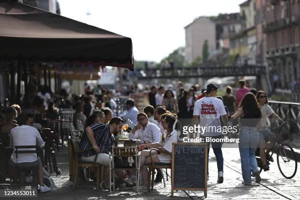 Customers sit outdoors at a restaurant in the Navigli neighborhood of Milan, Italy, on Saturday, Aug. 7, 2021. Italy will restrict many leisure...