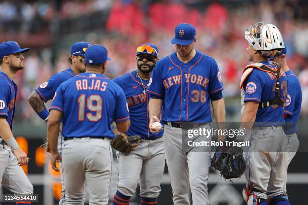 Tylor Megill of the New York Mets hands the ball to Manager Luis Rojas during the game between the New York Mets and the Philadelphia Phillies at...