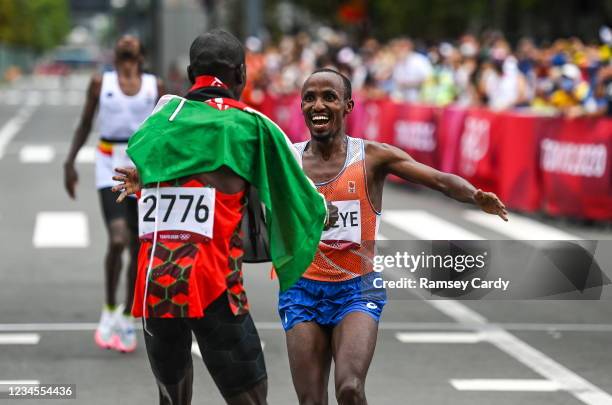 Hokkaido , Japan - 8 August 2021; Abdi Nageeye of Netherlands crosses the finish line in second place as he is greeted by first place Eliud Kipchoge...