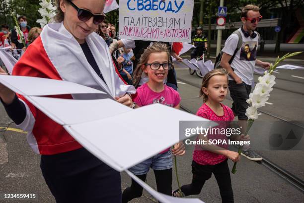 Young girl holds a symbolic flower showing solidarity with the 600 victims incarcerated by President Alexander Lukashenkos regime during the...