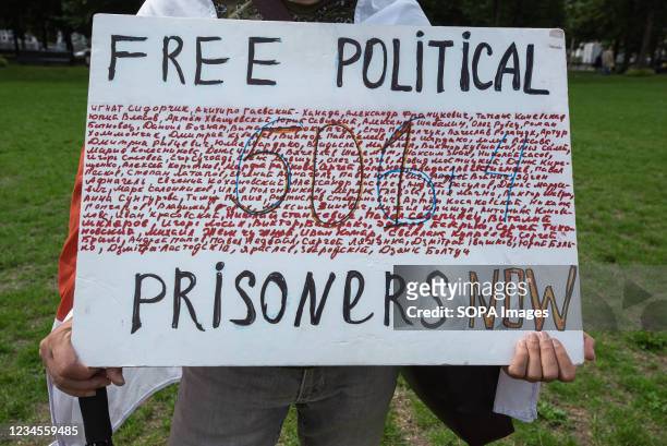 Protester holds a placard showing some of the 600 victims incarcerated by President Alexander Lukashenkos regime during the demonstration. 1 year...