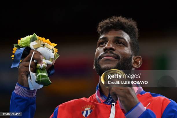 Gold medallist Cuba's Andy Cruz celebrates on the podium during the victory ceremony for the men's light boxing final bout during the Tokyo 2020...