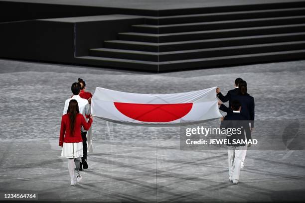 The Olympic flag is carried during the closing ceremony of the Tokyo 2020 Olympic Games, at the Olympic Stadium, in Tokyo, on August 8, 2021.