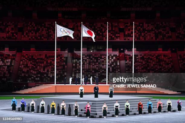 Performers sing the Japanese national anthem as the Olympic flag and Japan's flag are raised during the closing ceremony of the Tokyo 2020 Olympic...