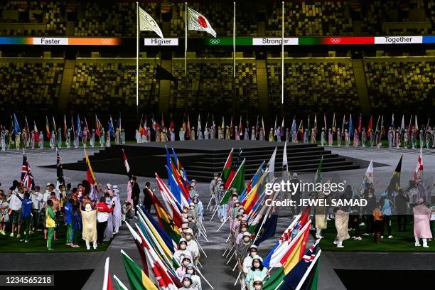 Athletes delegations pose with their national flag as they arrive during the closing ceremony of the Tokyo 2020 Olympic Games, at the Olympic...