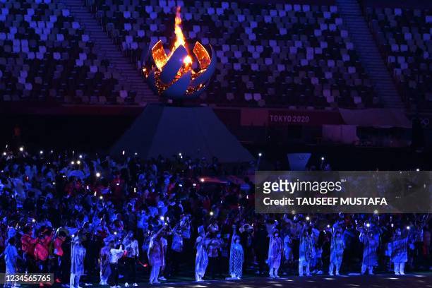 Athletes gather next to the Olympic Cauldron during the closing ceremony of the Tokyo 2020 Olympic Games, at the Olympic Stadium, in Tokyo, on August...