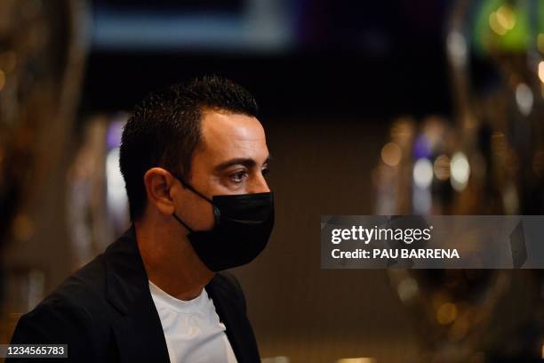 Barcelona's former Spanish midfielder Xavi attends a press conference by Barcelona's Argentinian forward Lionel Messi at the Camp Nou stadium in...