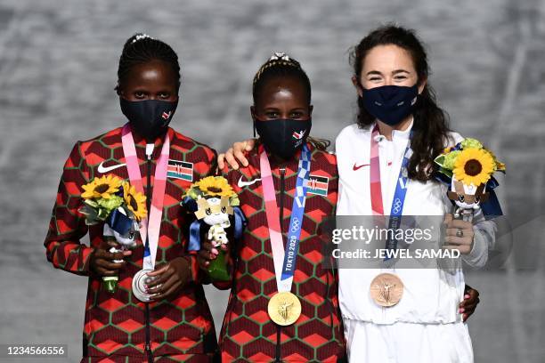 Second-placed Kenya's Brigid Kosgei, first-placed Kenya's Peres Jepchirchir and third-placed USA's Molly Seidel celebrate on the podium during the...