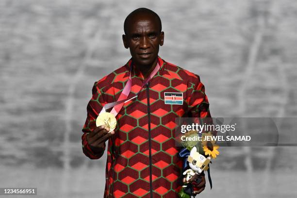 First-placed Kenya's Eliud Kipchoge celebrates on the podium during the victory ceremony of the men's marathon event as part of the closing ceremony...