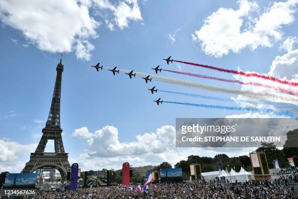 French aerial patrol 'Patrouille de France' fly over the fan village of The Trocadero set in front of The Eiffel Tower, in Paris on August 8, 2021...