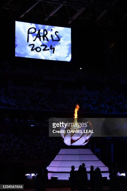 Video announcing the next Olympics Game of Paris 2024 is shown next to the Olympic Cauldron and the Olympic flame during the closing ceremony of the...