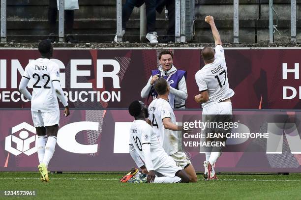 Lille's Turkish forward Burak Yilmaz celebrates with teammates after scoring his team's third goal during the French L1 football match between FC...