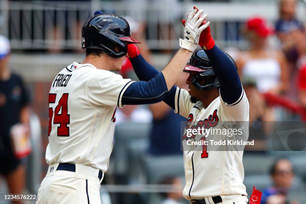 Ozzie Albies of the Atlanta Braves reacts with Max Fried after hitting a two run home run in the third inning of an MLB game against the Washington...