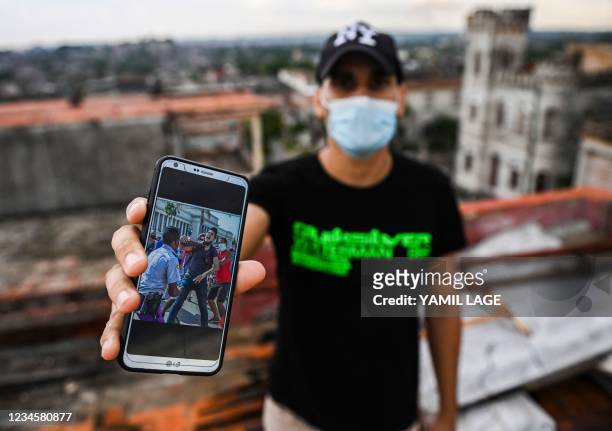 Cuban Rolando Remedios shows a photo of him being arrested during the July 11 protests on his mobile phone at his home in Havana, on August 7, 2021....